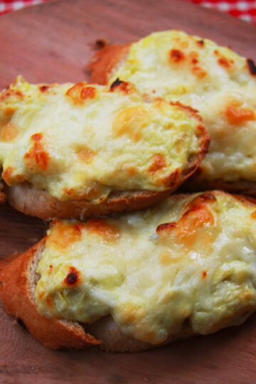 Three Toasted Artichoke Bruschetta on a Wooden Cutting Board