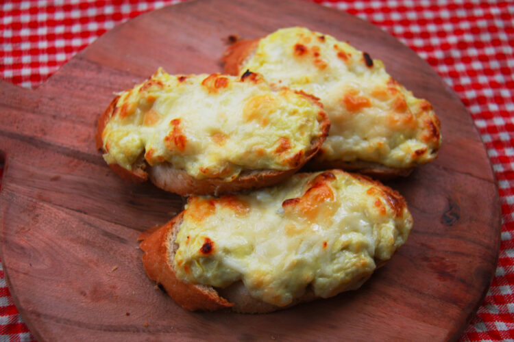 Three Toasted Artichoke Bruschetta on a Wooden Cutting Board